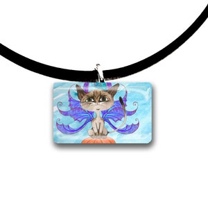 May include: A rectangular pendant necklace featuring a cartoon cat with blue and purple fairy wings, sitting on an orange pumpkin. The cat has brown fur and is set against a light blue watercolor background. The necklace has a black cord.
