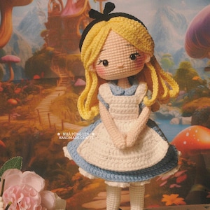 May include: Crocheted doll of a character from Alice in Wonderland, wearing a blue and white dress, black shoes, and a black bow. The doll has blonde hair and rosy cheeks. The background features a whimsical landscape with a castle and mushrooms. Text reads "MADE BY MY LOVELY CUSTOMER".