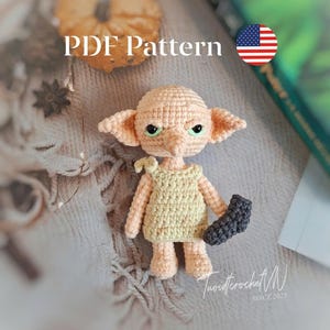 May include: A crocheted doll with large ears, green eyes, and a yellow dress, holding a dark gray sock. The doll is on a textured surface. The text "PDF Pattern" is visible.