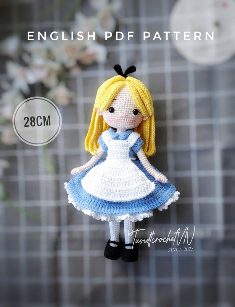 May include: A handmade crochet doll, 28cm tall, resembling Alice from Alice in Wonderland. The doll has yellow hair, a blue and white dress, and black shoes. The image includes the text "ENGLISH PDF PATTERN" and the artist's signature.
