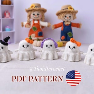 May include: Five small white crocheted ghost figures with black eyes and smiles, each wearing a different accessory: a black witch hat, a small orange pumpkin, purple earmuffs, an orange bow, and a black top hat. Two scarecrow dolls stand behind.
