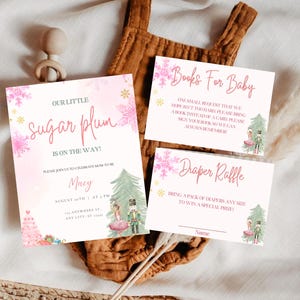 May include: Baby shower invitations with a pink and white design. The invitations include the text "Our Little Sugar Plum is on the Way!" and details for the event. Additional cards request books and a diaper raffle.