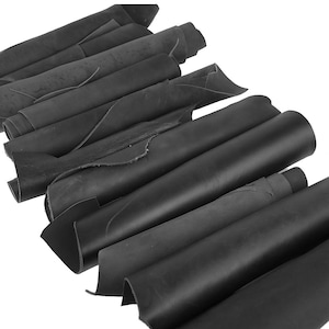 May include: A collection of rolled black leather hides. The hides are arranged in a diagonal pattern, with some unrolled to reveal the texture of the material. The leather appears to be thick and durable, suitable for various crafting projects.