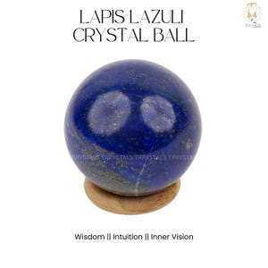 Puede incluir: Una bola de cristal de lapislázuli pulida, azul oscuro con motas doradas, sobre un pequeño soporte de madera. El texto "LAPIS LAZULI CRYSTAL BALL" está en la parte superior. Debajo, el texto dice "Wisdom || Intuition || Inner Vision."