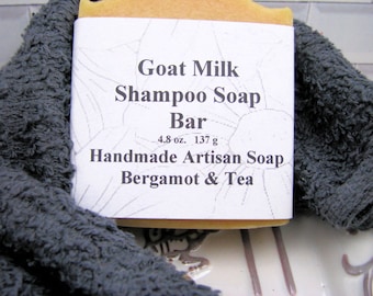 May include: A white bar of goat milk shampoo soap with a label that reads "Goat Milk Shampoo Soap Bar 4.8 oz. 137 g Handmade Artisan Soap Bergamot & Tea".