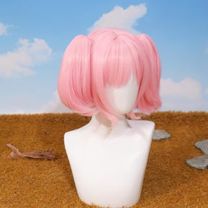 Back view of the Madoka Kaname pink twin tail wig showing the adjustable straps and rose net cap construction for a secure fit. The wig is crafted from high-temperature resistant matte synthetic fibers, allowing safe styling. Perfect for Puella Magi Madoka Magica fans, platform gamers, and cosplayers looking for a quality accessory for anime conventions, photoshoots, and birthday gifts.