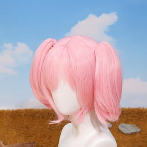 Side angle of Madoka Kaname cosplay wig with pink twin tails attached using secure tiger-mouth clips. The breathable rose net cap ensures comfort during long wear at conventions or photoshoots. This synthetic heat-resistant wig is a perfect choice for platform game player gifts, cosplay birthday surprises, and anime holiday celebrations. Ideal for transforming into your favorite magical girl character with ease.