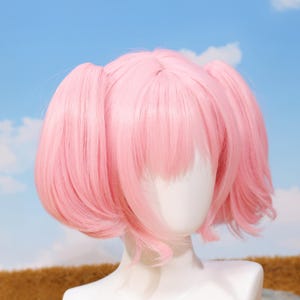 Back view of the Madoka Kaname pink twin tail wig showing the adjustable straps and rose net cap construction for a secure fit. The wig is crafted from high-temperature resistant matte synthetic fibers, allowing safe styling. Perfect for Puella Magi Madoka Magica fans, platform gamers, and cosplayers looking for a quality accessory for anime conventions, photoshoots, and birthday gifts.