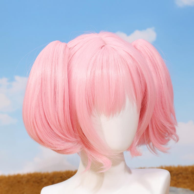 Back view of the Madoka Kaname pink twin tail wig showing the adjustable straps and rose net cap construction for a secure fit. The wig is crafted from high-temperature resistant matte synthetic fibers, allowing safe styling. Perfect for Puella Magi Madoka Magica fans, platform gamers, and cosplayers looking for a quality accessory for anime conventions, photoshoots, and birthday gifts.