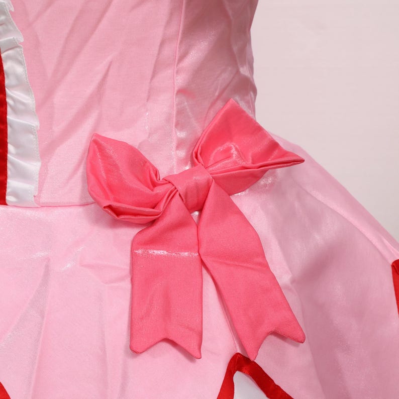 Detail shot of the accessories included with the Madoka Kaname cosplay set: matching gloves, pink choker with red gem, white socks, and decorative headwear. Each accessory is made to match the anime’s character design, offering a complete transformation into Madoka Kaname. Suitable for cosplay festivals, anime conventions, and as a gamer gift for fans of platform-style magical girl games. An excellent costume for collectors or performers.