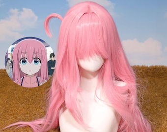 May include: A long, pink wig with bangs and a small ponytail, displayed on a mannequin head. The wig is styled with long, flowing layers. An anime character image is in the background.