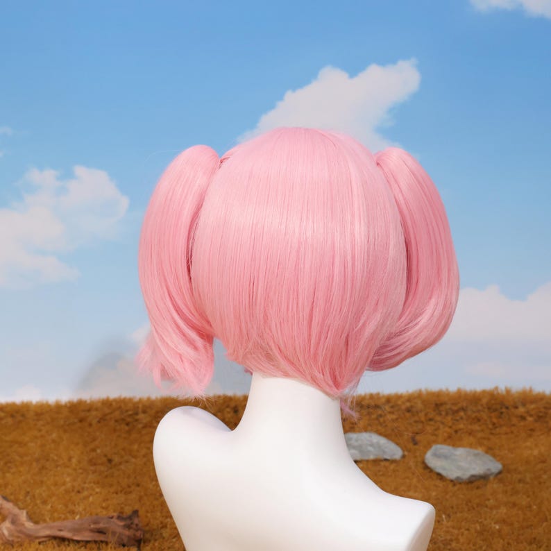 Close-up view of the Madoka Kaname pink twin tails cosplay wig showing the high-quality synthetic matte fiber texture and vibrant color. The wig is styled for anime accuracy, including parted bangs and curled twin tail tips. This heat-resistant wig is perfect for conventions, cosplay birthday gifts, holiday celebrations, platform gaming enthusiasts, and anyone looking to bring Madoka’s magical girl spirit to life.