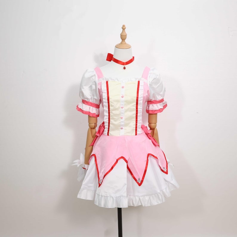 Front view of a model wearing the complete Madoka Kaname cosplay costume, highlighting the charming details of the gloves, choker, and headwear included in the set. The outfit recreates the iconic look of Madoka from Puella Magi Madoka Magica with incredible accuracy, making it ideal for fans of magical girl anime. Lightweight and available in sizes from XS to 3XL, it suits a wide range of body types for cosplay or themed holiday events.