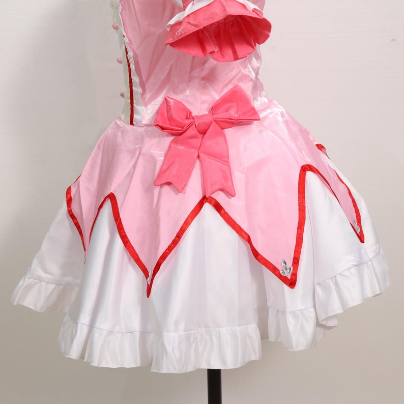Front view of a model wearing the complete Madoka Kaname cosplay costume, highlighting the charming details of the gloves, choker, and headwear included in the set. The outfit recreates the iconic look of Madoka from Puella Magi Madoka Magica with incredible accuracy, making it ideal for fans of magical girl anime. Lightweight and available in sizes from XS to 3XL, it suits a wide range of body types for cosplay or themed holiday events.