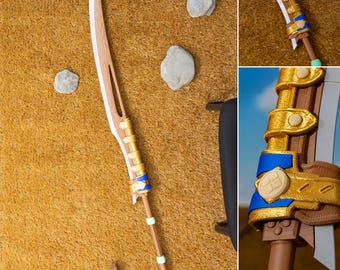 May include: A detailed, handcrafted sword with a light brown wooden blade and handle. The handle features gold and blue accents, with a white edge. The sword is set against a textured, tan background with small rocks, showcasing its intricate design.