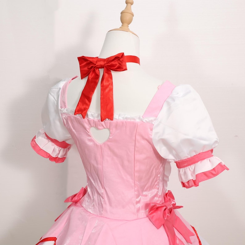 Close-up image of the Madoka Kaname magical girl cosplay dress showing the high-quality cotton-nylon blend and red satin detailing. The white wedding satin bodice is paired with layered skirts trimmed in pink and red, giving it an authentic anime appearance. Ideal for cosplay girls who want a vibrant, lightweight costume for conventions or gaming expos. Great holiday gift for anime lovers, platform gamers, or magical girl enthusiasts looking for a premium outfit.