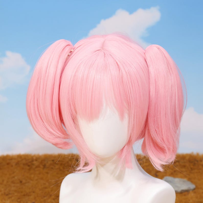 Beautiful pastel pink Madoka Kaname wig displayed on a mannequin head, highlighting the smooth, heat-resistant synthetic fibers and pre-styled twin tails. This cosplay wig accurately replicates the character’s hairstyle from Puella Magi Madoka Magica and comes with breathable rose net cap for comfort. Suitable for cosplayers, anime collectors, and fans seeking authentic cosplay accessories or thoughtful gifts for gamers and anime lovers.