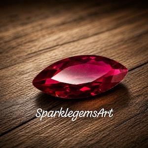 Può includere: Una gemma di rubino sfaccettata a taglio marquise, di colore rosso intenso. La gemma è appoggiata su una superficie di legno. Il testo "SparklegemsArt" è visualizzato in bianco.