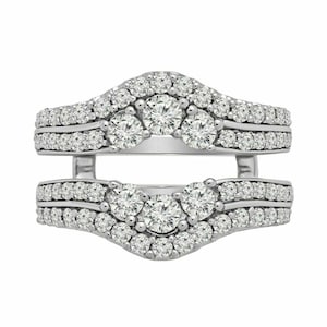 May include: A silver-toned ring guard featuring two curved bands connected by vertical bars. The bands are encrusted with numerous small, round, clear stones and feature three larger, prominent round stones centered on each curved section.