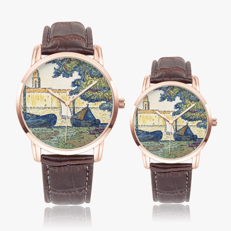 May include: Two rose gold watches with brown leather straps. The watch faces feature a colorful landscape painting with boats and a building. The watches are displayed on a white background.