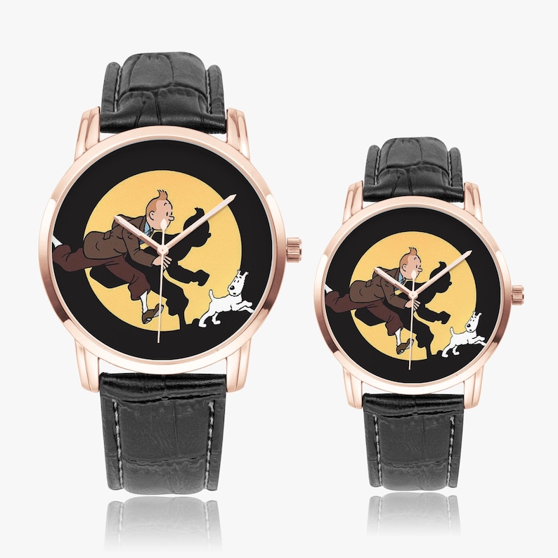 Op de afbeelding: Twee ros&eacute;gouden horloges met zwarte leren bandjes. De wijzerplaten tonen een cartoonafbeelding van een man en een witte hond tegen een gele achtergrond. De wijzers van het horloge zijn zwart.