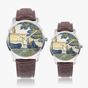 May include: Two wristwatches with brown leather straps and silver-toned cases. The watch faces feature a colorful landscape painting with boats, a building, and trees. The watches are displayed on a white background.