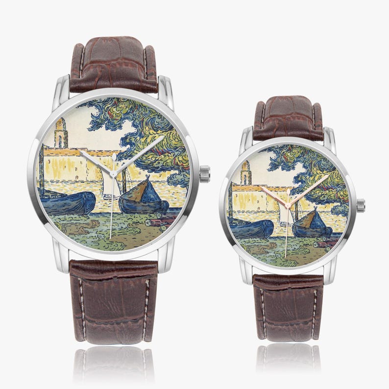 May include: Two wristwatches with brown leather straps and silver-toned cases. The watch faces feature a colorful landscape painting with boats, a building, and trees. The watches are displayed on a white background.