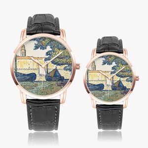 May include: Two rose gold watches with black leather bands. The watch faces feature a colorful painting of boats and a building. The watch hands are gold. The watches are displayed on a white background.