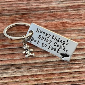 Llavero inspirado en Firefly y Kaylee, con la frase "Todo está BRILLANTE, Capitán, no se preocupe", estampada a mano y con dije a elección.