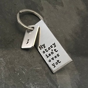 Hand stamped &quot;My story isn&#39;t over yet&quot; semicolon project keychain