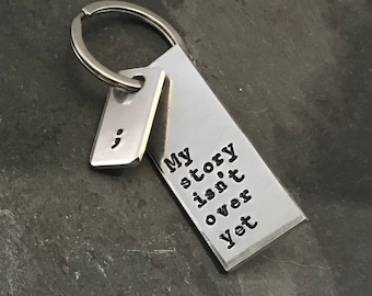 Hand stamped &quot;My story isn&#39;t over yet&quot; semicolon project keychain