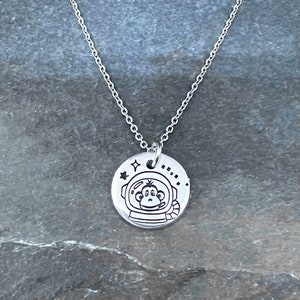 Micro astronaut monkey hand stamped necklace