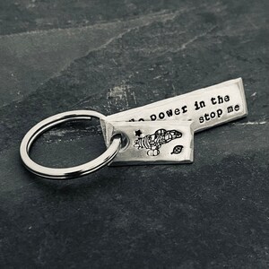 Llavero inspirado en la luciérnaga con el mensaje "Ningún poder en el Verso puede detenerme" estampado a mano y dije Serenity estampado a mano.