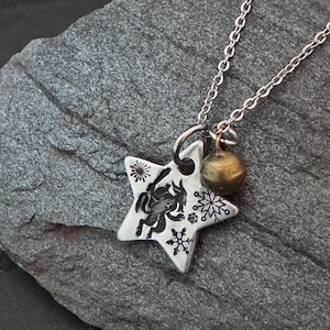 Krampus dancing on a small star hand stamped necklace