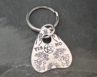 Hand stamped Ouija demon pony planchette keychain.