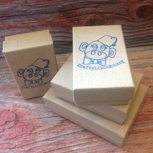 May include: Stack of three brown cardboard boxes with a blue monkey logo and the text "CraftyLikeAMonkey" printed on the top box.