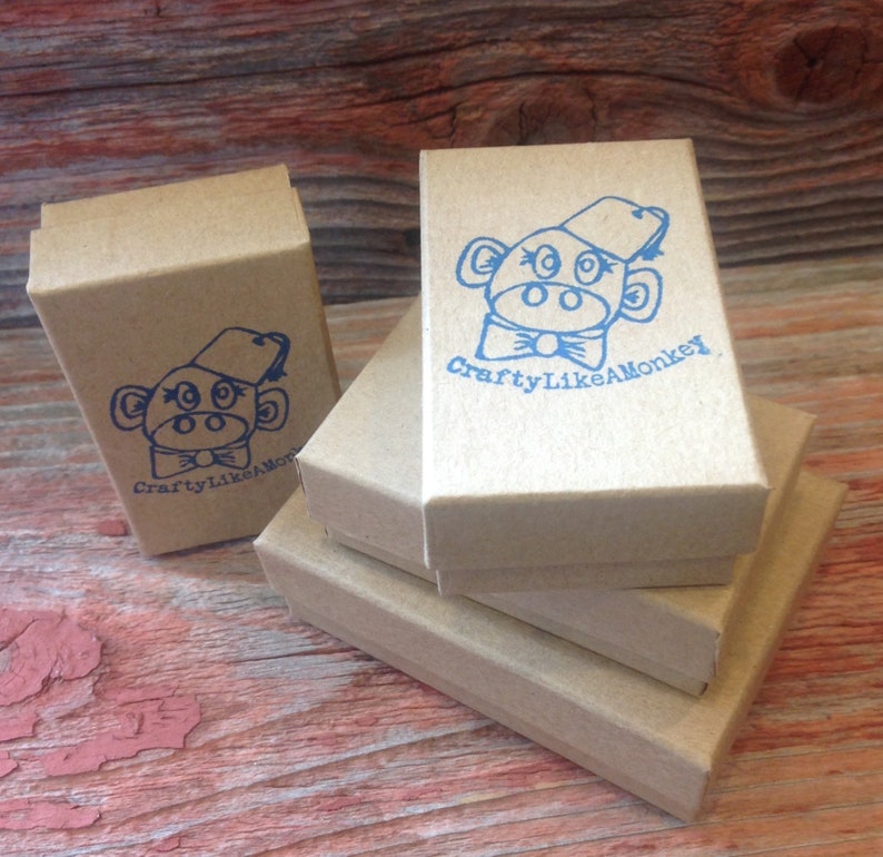 May include: Stack of three brown cardboard boxes with a blue monkey logo and the text "CraftyLikeAMonkey" printed on the top box.