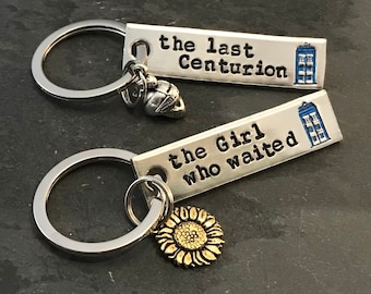 Puede incluir: Dos llaveros de plata con texto grabado y dijes. El primer llavero tiene un dije de plata de una TARDIS y el texto "the last Centurion". El segundo llavero tiene un dije de plata de un girasol y el texto "the Girl who waited".