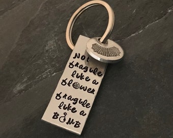 Hand stamped "Not fragile like a flower...” RBG quote keychain.
