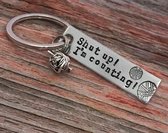 May include: Silver keychain with a small yarn ball charm and a tag that reads "Shut up! I'm counting!"