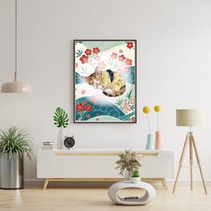 Könnte beinhalten: Gerahmter Kunstdruck mit einer schlafenden Katze in einem gelben Kimono, vor einem Hintergrund aus roten Blumen und blauen Wellen. Das Kunstwerk hat eine japanische Ästhetik, mit einem schwarzen Rahmen und einem weißen Hintergrund.