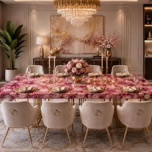Könnte beinhalten: Ein luxuriöses Esszimmer mit einem großen rechteckigen Tisch mit einer rosa-weißen Musterung. Cremefarbene Stühle mit goldenen Beinen umgeben den Tisch. Ein großer Kronleuchter erhellt den Raum, und ein Blumengesteck sorgt für Eleganz.