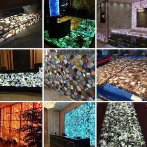 May include: A collection of backlit agate stone slabs and surfaces featuring diverse natural patterns and vibrant colors including blue, orange, green, and brown. These translucent gemstone panels are used for countertops, wall cladding, and flooring, showcasing intricate mineral formations and polished textures.