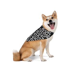 Könnte beinhalten: Ein Shiba Inu-Hund trägt ein schwarz-weißes Halstuch mit sich wiederholendem Text. Der Hund ist hellbraun und weiß mit einem fröhlichen Gesichtsausdruck, die Zunge heraus. Das Halstuch ist um den Hals des Hundes.