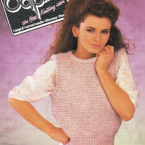 May include: A woman wearing a pink knitted vest over a white blouse. The vest has a ribbed hem and neckline. The image has text that reads "Oddpins Knitting idea". The background is a gradient of pink and purple.