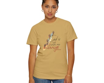 May include: Mustard-colored t-shirt featuring the text "God is with me always" in a script font, accompanied by a graphic of footprints. The shirt is made of a soft material and has a classic crew neck.