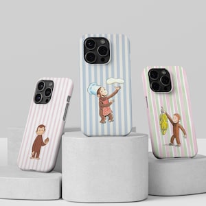 May include: Three phone cases with vertical striped patterns in pink, blue, and green. Each case features a cartoon monkey illustration. One monkey holds a banana bunch, another holds a dough, and the third holds a brown object.