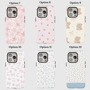 May include: A collection of phone cases with various designs. Options include cases with pink floral patterns, pink hearts, teddy bears, bows and cherries, blue floral patterns, and a blue-bottomed floral design. Each case has a camera cutout.
