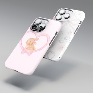 May include: Two phone cases. One is light pink with a watercolor bunny inside a heart-shaped frame. The other is white with a pattern of bows, stars, and bunnies. Both cases have a glossy finish.