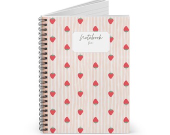 May include: A spiral-bound notebook with a cover featuring a pattern of red strawberries on a light pink striped background. The notebook is open, revealing lined pages. The cover has the text "Notebook from" in a handwritten font.